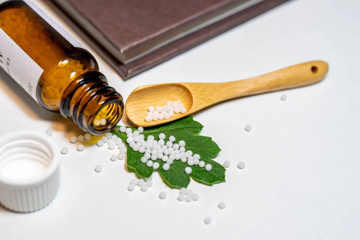 Homöopathische Globuli, die auf einem Holztisch stehen